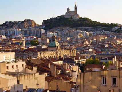 Vue du centre historique de Marseille très minéralisé au premier plan et de la colline plus végétalisée où se dresse la Basilique Notre-Dame-de-la-Garde en arrière-plan