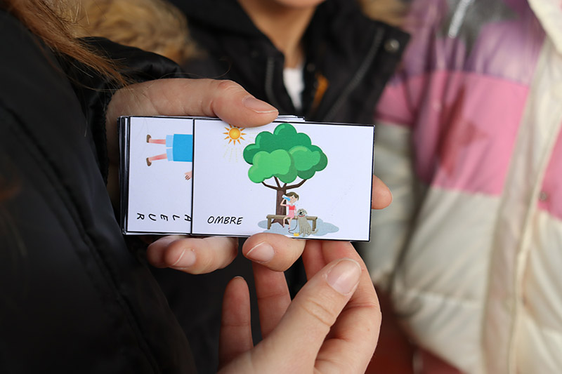Dans le cadre d’un atelier collaboratif pour la végétalisation d’une cour d’école, des enfants manipulent des cartes avec des dessins représentants les aménagements qu’ils désirent.
