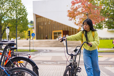 collégienne qui s’apprête à stationner son vélo sur le parking à vélos de son collège
