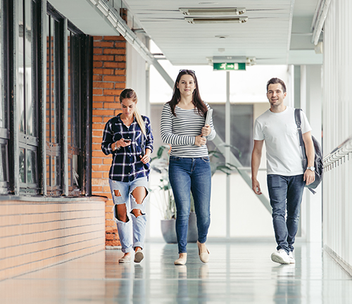 3 étudiants marchent dans les couloirs de leur lycée.