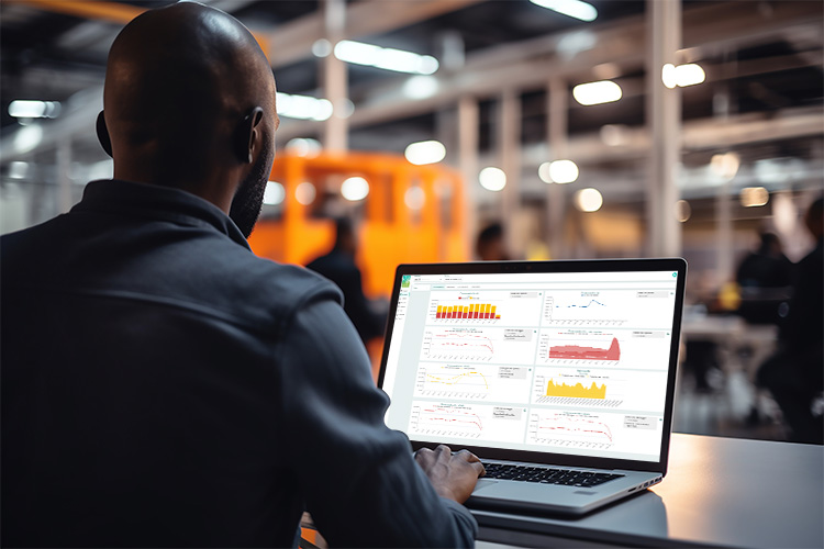 Chef de production industrielle qui consulte ses tableaux de bord de suivi énergétique sur PC